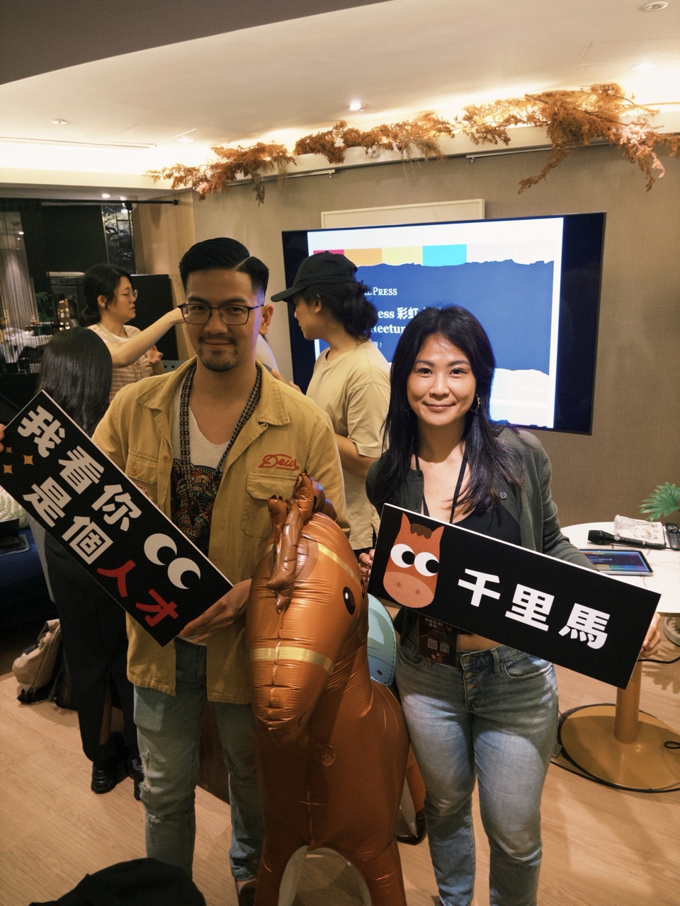 兩位參與者拿著千里馬與「我看你是個人才」的造型牌合影